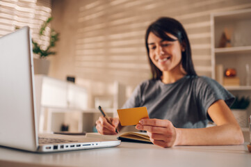 Fototapeta premium Blurred shot of a smiling woman . Focus on a credit card between her fingers.