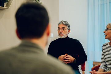 Senior man talking about his mental health on a group therapy session