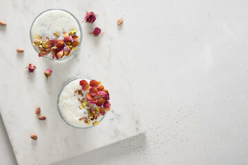 Indian Sweet lassi with saffron and rose water on white background. Traditional healthy freshness lassi made of yogurt, water, spices and ice. View from above. Copy space.