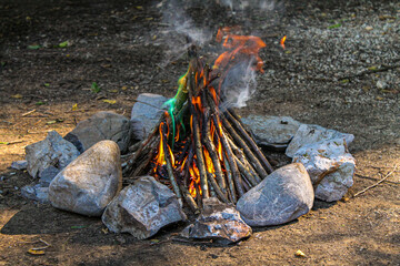 A campfire with flames of different colors in a stone hearth