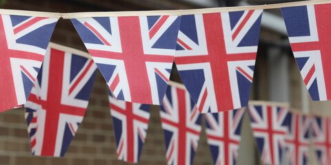 Fototapeta na wymiar String of union jack bunting flag decorations for a celebration in the United Kingdom. Generative ai