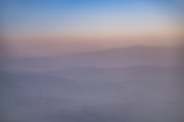Abstract view of blurry hills and mountain ranges at sunset, warm sunset hues in the mountains in the evening