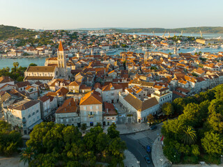 Fototapeta na wymiar Aerial shot of magnificent Venetian city on the Adriatic Sea - Trogir, Croatia. Morning shot of old town Trogir with orange tiled roofs