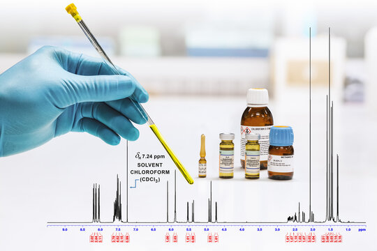 Hand of scientist shows yellow sample solution and NMR spectrum of sample was analyzed by NMR spectroscopy method in chloroform. NMR solvent glass bottles, chloroform, pyridine, DMSO, D2O, methanol.