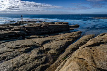 Single Person On Stone Beach Of Guilvinec At The Finistere Atlantic Coast In Brittany, France