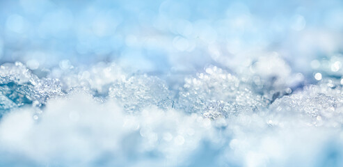 Winter background, banner with selective focus. Close-up view of melted snow with ice formation,...