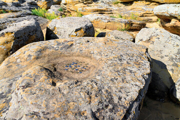 Natural landscape - close up view of an ancient stone altar among the boulders of sandstone,...