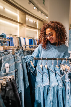 Black Woman Choosing Clothes In Shop