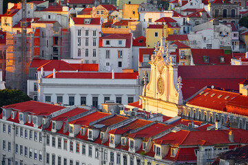 Lisbon, Portugal. Red roofs of buildings and fragment vintage lisbon temple during sunset. Top view at the beautiful city. Alfama old town distrivt Lisboa