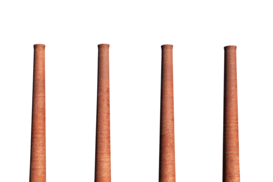 Four old brick factory smokestacks isolated with cut out sky.