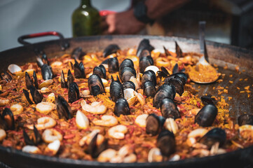 Piekna hiszpańska paella z małżami i innymi owocami morza. 