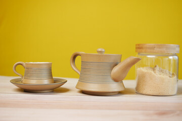 brown sugar in a container and tea cup on table 