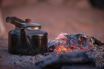Wadi Rum w Jordanii. Czajnik obok dogasającego ogniska na pustyni.  - obrazy, fototapety, plakaty
