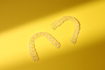 Transparent plastic dental aligners on a colored background