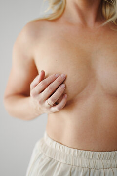 the woman covers her breasts with her hand. without face