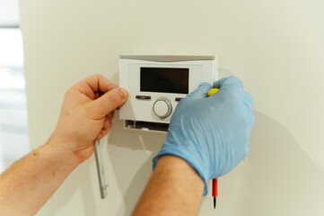 electrician, male electrician repairs smart home with a screwdriver. electrical engineer installs...