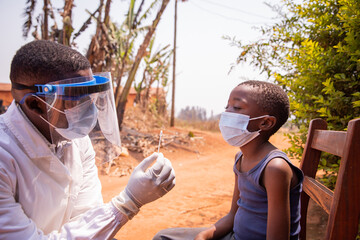 A doctor holding a swab to perform a molecular test on a child in Africa