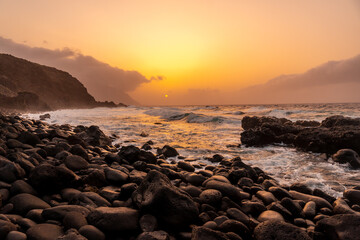 El Hierro Island. Canary Islands, landscape of stones next to Charco azul in spring orange sunset