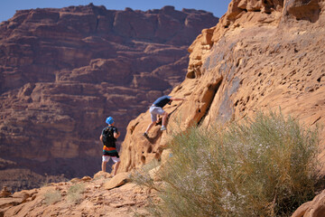 Wadi Rum w Jordanii. Osoby wspinające się po pustynnych skałach. 