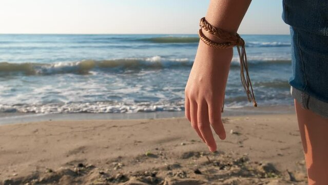 Wear vintage bracelet on traveling. A view of pretty girl hand with vintage bracelet during sea traveling in summer.
