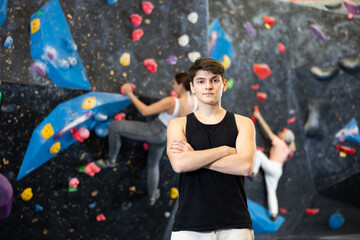 Young male climber getting ready to climb wall in gym