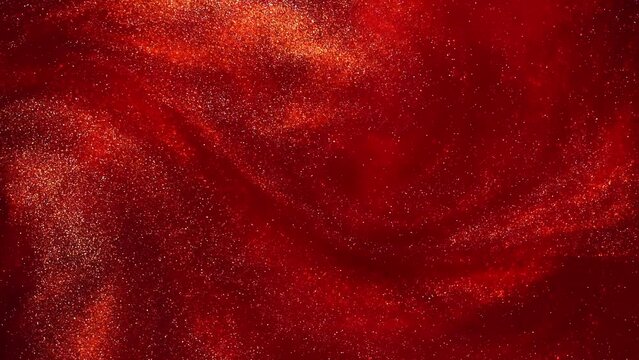 Slow Motion Swirling gold particles in dark red liquid. Golden particles slowly move and form fantastic, impressive maelstrom. A magical galaxy of countless golden dust particles in red fluid motion.