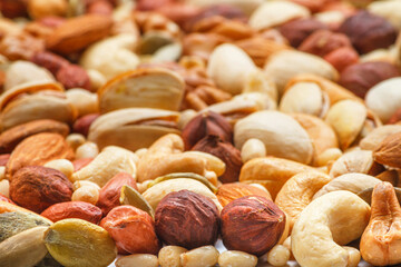 Different types of nuts and seeds, photo with selective focus. Peeled walnut, hazelnuts, peeled...