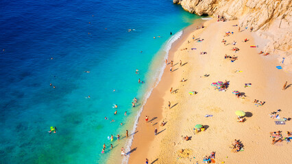 Aerial view on beach and umbrellas. Sumer vacation and adventure. Beach and blue water. Top view from drone at beach and azure sea.