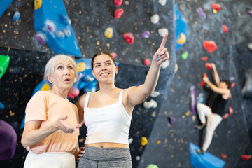 Young and older women looking around in climbing gym