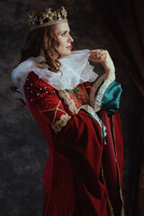 pensive medieval queen in red dress with white collar
