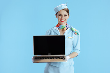 female flight attendant on blue showing laptop blank screen