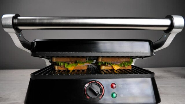 Cooking sandwiches on an electric grill. white bread toast