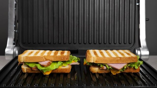 Cooking sandwiches on an electric grill. white bread toast.