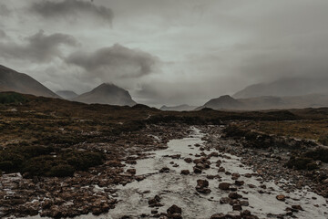 Large mountains loom over a rocky field