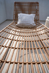 Close up on a wicker sun lounge chair on a sun deck.