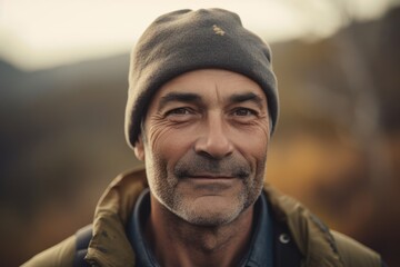 Portrait of a senior man with hat in the autumn forest.