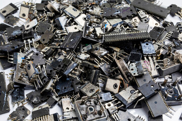 A pile of ICs, transistors, diodes that are damaged from use. Used electronic components, electronic waste