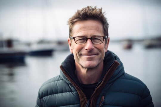 Portrait of handsome man with eyeglasses standing in front of yachts