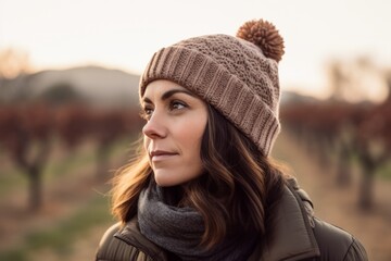 Portrait of a beautiful young woman with hat and scarf in the countryside