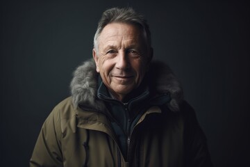 Portrait of a senior man in winter jacket on a dark background
