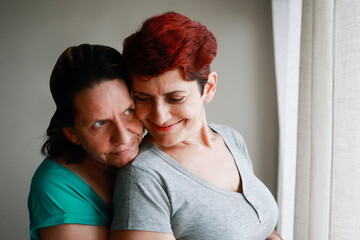 Gay senior lesbian couple hugging indoor at home - Diversity, LGBTQ lesbian family and love concept