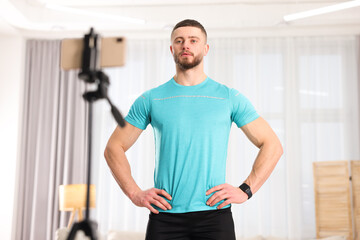 Naklejka na ściany i meble Trainer streaming online fitness lesson with phone at home