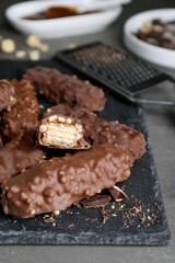 Tasty chocolate bars with caramel on light grey table, closeup