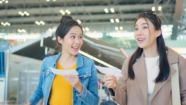 Asian young women passenger walk in airport terminal to boarding gate.