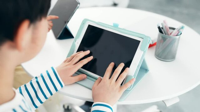 タブレットの画面をタッチする男の子