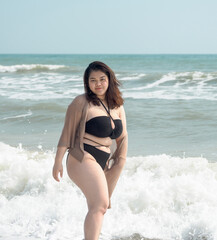 Portrait young woman asian chubby fat cute beautiful one person in bikini black sexy frontview tropical sea beach white sand clean and blue sky background calm nature ocean wave water travel fun happy