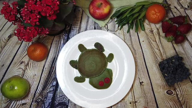 Plate with turtle pancake spins on the wooden table and dissapear. Stop motion flat lay. High quality 4k footage