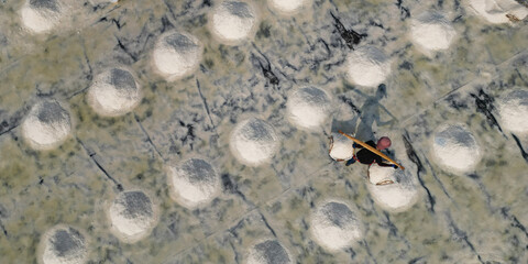  Aerial view of worker harvesting salt in salt field at Ban Laem-Thailand	