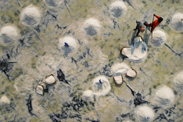  Aerial view of worker harvesting salt in salt field at Ban Laem-Thailand	