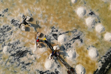  Aerial view of worker harvesting salt in salt field at Ban Laem-Thailand	
